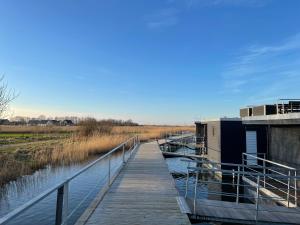 a wooden walkway over a body of water at Hausboot Optima in Wangerland