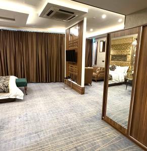 a hotel room with a bed and a mirror at Bloom Hotel in Baghdād