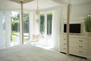 a bedroom with a bed and a dresser with a television at Meer Weiss in Wangerland