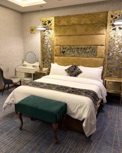 a bedroom with a large bed with a large headboard at Bloom Hotel in Baghdād