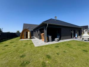 a black house with a lawn in front of it at Koje Seelöwe in Wangerland