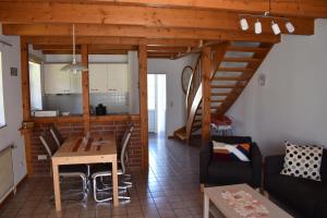 a living room with a table and a kitchen at Nordlys in Hooksiel