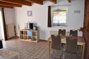 a kitchen with a dining room table and chairs at Nordlys in Hooksiel