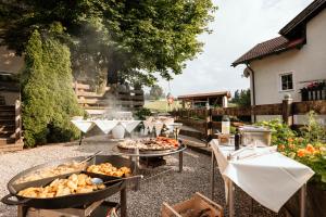 a patio with a grill with food on it at Hotel Mariasteinerhof in Mariastein