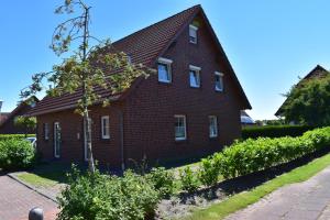 a red brick house with a gambrel roof at Tegeler Plate 26 in Wangerland