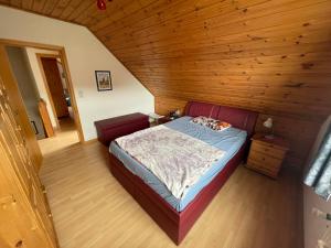 a bedroom with a bed in a wooden room at Haus Tillmann mit Hund in Hooksiel in Wangerland