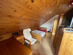a room with a bed in a wooden cabin at Haus Tillmann mit Hund in Hooksiel in Wangerland