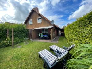 a house with two lounge chairs in the yard at Haus Tillmann mit Hund in Hooksiel in Wangerland
