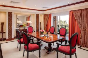 a dining room with a wooden table and red chairs at Kampala Serena Hotel in Kampala