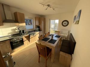 a kitchen with a table and chairs and a clock at Wangernest in Wangerland