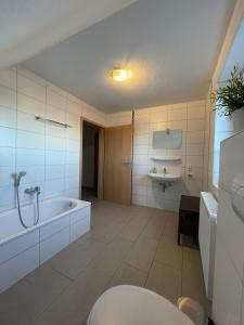 a bathroom with a tub and a toilet and a sink at Wangernest in Wangerland +16 photos