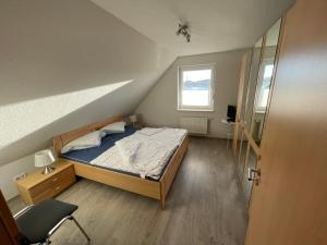a small bedroom with a bed and a window at Wangernest in Wangerland