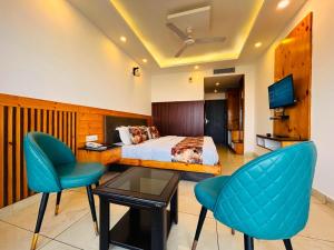 a hotel room with a bed and two chairs at The Pine Woods - A Four Star Luxury Resort In Mussoorie Near JW Marriott in Mussoorie