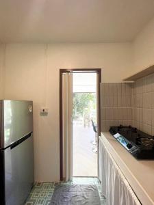 a kitchen with a refrigerator and a door to a patio at Simple Cozy House Coconut Lane in Hinkong