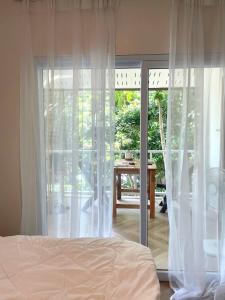 a bedroom with a bed and a sliding glass door at Simple Cozy House Coconut Lane in Hinkong +1 photo