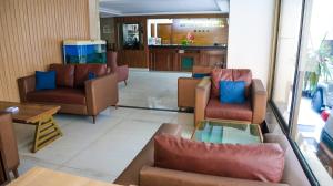 a living room with couches and chairs and a kitchen at Orient Prince Hotel in Beirut