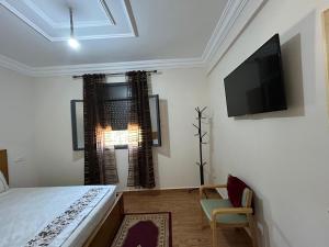 a bedroom with a bed and a flat screen tv at DAR Assoul in Khenifra
