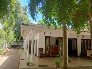 a house with palm trees in front of it at Sathkara Guest House in Anuradhapura