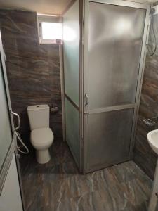 a bathroom with a shower and a toilet and a sink at Sathkara Guest House in Anuradhapura
