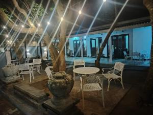 a patio with a table and chairs and a vase at Sathkara Guest House in Anuradhapura
