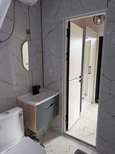 a bathroom with a toilet and a sink and a mirror at Comfort Point Hotel in Bishkek +55 photos