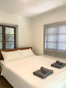 a bedroom with a white bed with towels on it at Simple Cozy House Coconut Lane in Hinkong
