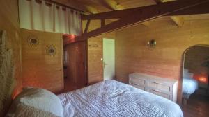 a bedroom with a bed and a wooden wall at Chalet Ty Kerouannec in Guilligomarcʼh