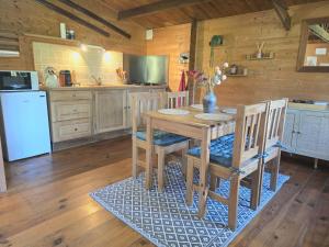 a kitchen with a table and chairs and a refrigerator at Chalet Ty Kerouannec in Guilligomarcʼh