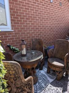a patio with a table and chairs and a brick wall at The Travellers Retreat in Neston