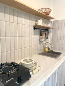 a kitchen with a stove and a counter top at Simple Cozy House Coconut Lane in Hinkong