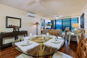 a living room with a glass table and chairs at Kanai A Nalu 318 in Wailuku