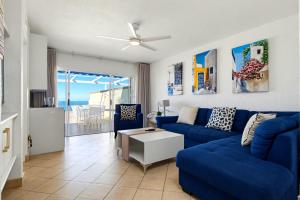 a living room with a blue couch and a table at Club 10 Management in Ballito
