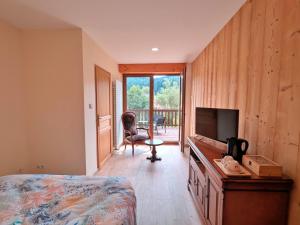a bedroom with a bed and a desk with a television at Chambre Jonquille in Rehaupal