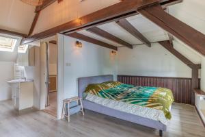 a bedroom with a bed in a room with wooden ceilings at B&B de oude melkfabriek in Valkenswaard