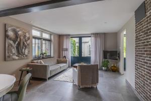 a living room with a couch and a tv at B&B de oude melkfabriek in Valkenswaard