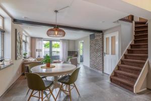 a dining room and living room with a table and chairs at B&B de oude melkfabriek in Valkenswaard