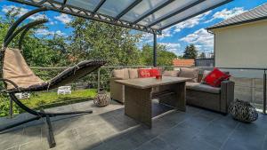 a patio with a hammock and a table and chairs at Luxbor Villa in Eger