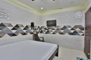 a bedroom with a bed and a tv on the wall at SAMPATH RESIDENCY in Palni