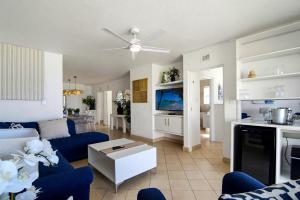 a living room with blue couches and a tv at Club 10 Management in Ballito