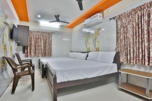 a bedroom with a bed and a chair in it at SAMPATH RESIDENCY in Palni