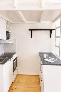 a kitchen with white appliances and a wooden floor at Alppila Lodge Studio in Helsinki