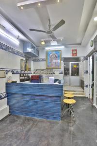 a restaurant with a blue counter and yellow stools at SAMPATH RESIDENCY in Palni