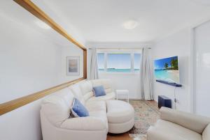 a living room with two white couches and a window at Silver Waters | Private Cove | Ocean Views in Zilzie