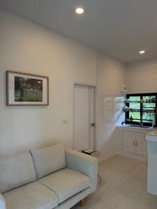 a living room with a couch and a kitchen at Moon & Banana in Ko Phangan