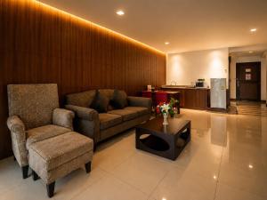 a living room with a couch and a chair and a table at Baywalk Residence Pattaya in Pattaya