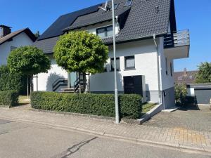 a white house with a black roof at Apartment nähe Ettlingen - 15 min zur Messe Karlsruhe in Malsch