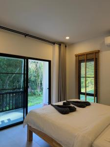 a bedroom with a bed and a large window at Moon & Banana in Ko Phangan
