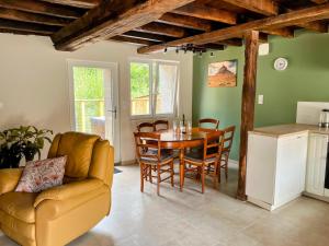 a kitchen and dining room with a table and chairs at Maison de vacances proche de Pontmain in Saint-Mars-sur-la-Futaie