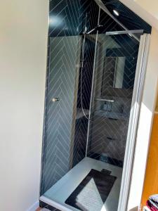 a shower with a glass door in a bathroom at Maison de vacances proche de Pontmain in Saint-Mars-sur-la-Futaie