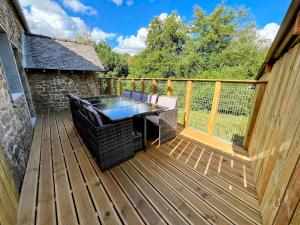 a wooden deck with a table and chairs on it at Maison de vacances proche de Pontmain in Saint-Mars-sur-la-Futaie